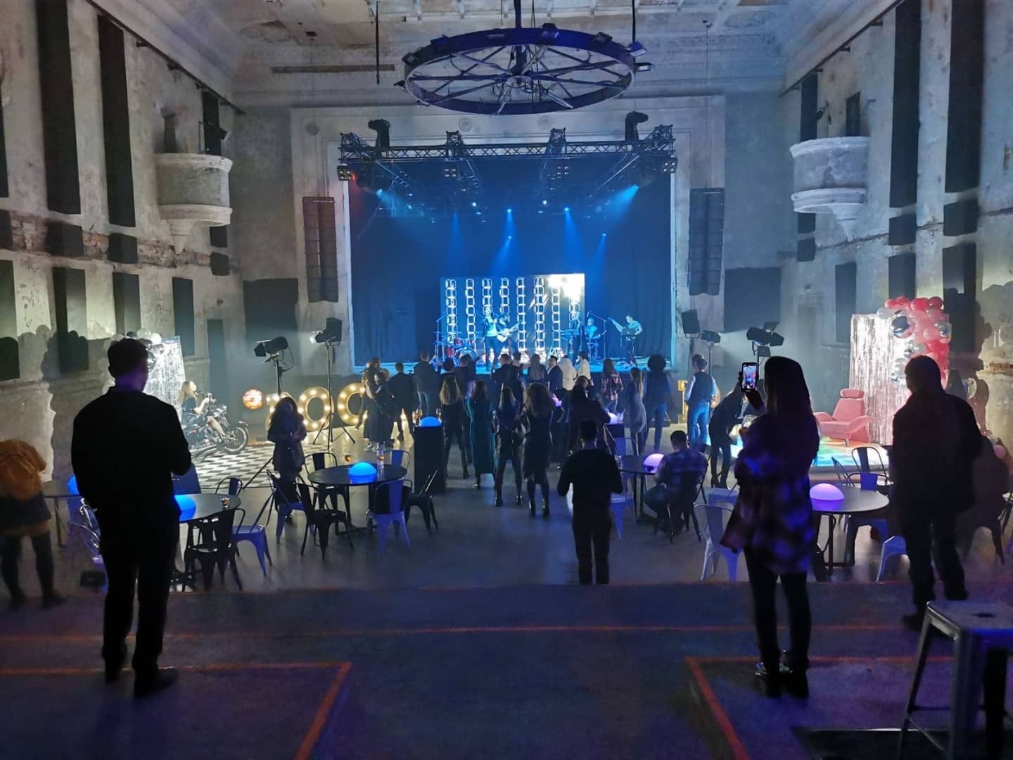Įmonės renginys industrinėje erdvėje su scena, svečiais ir pramogų zona